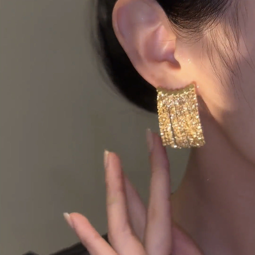 Lange oorbellen met gebogen staaf en kwast