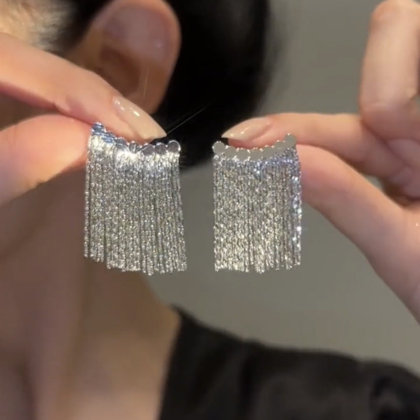 Lange oorbellen met gebogen staaf en kwast